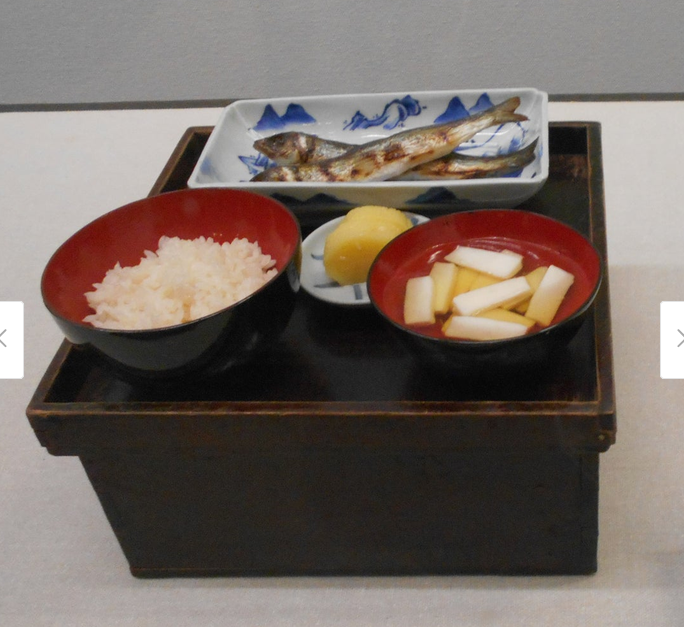 飯、汁物、魚、漬物を載せた膳の写真